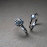 Close-up image of luxury diamond engagement rings on a neutral background.